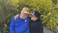 Photo of a couple smiling with park in the background